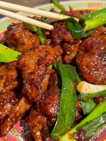 Lamb stir-fry sizzling in a wok with fresh scallions for a quick, flavorful weeknight meal.