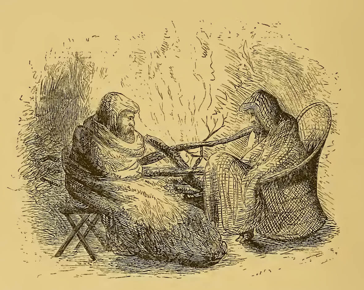 two men bundled in blankets before a fire