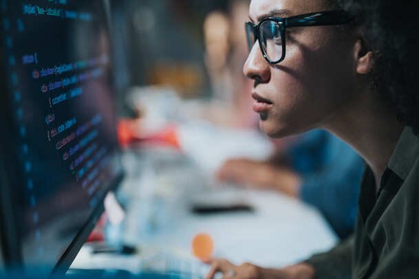 Man with glasses programming in computer.