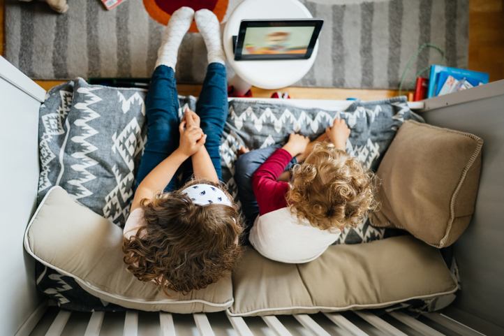 Children sitting while watching tablet