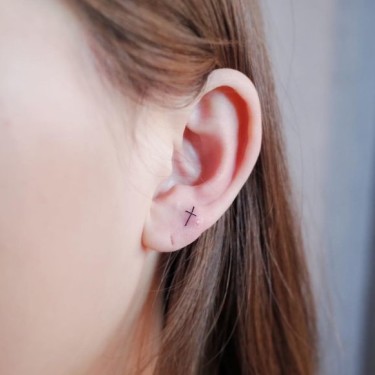 Cute Small Cross On Ear Tattoo