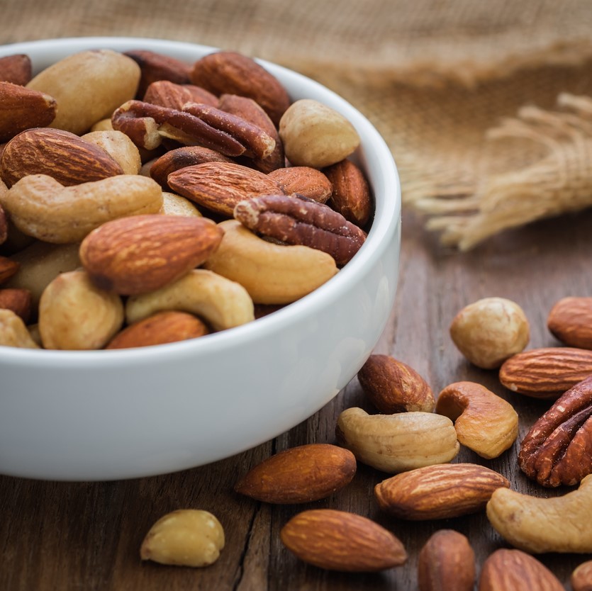 Mixed nuts on wooden table and bowl