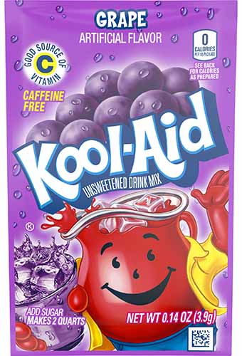 A close up vertical image of the horrible garish packaging of Grape Kool-Aid.