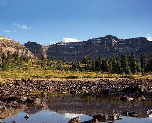 The late Precambrian-age Red Castle and Dead Horse Pass Formations, carved by Quaternary glaciers, form the cirque above Henrys Fork basin in the Uinta Mountains. A popular backpacking destination, Henrys Fork basin lies beneath the highest point in Utah, Kings Peak (13,528 feet; on the skyline in middle of photo). High Uintas Wilderness Area, Summit County. Photographer: Adam Hiscock © 2016