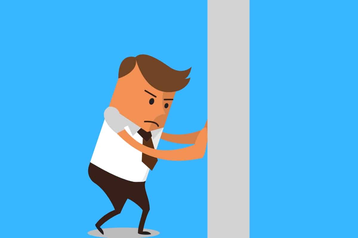 Cartoon graphic of a man in a suit trying to push a wall on a blue background.