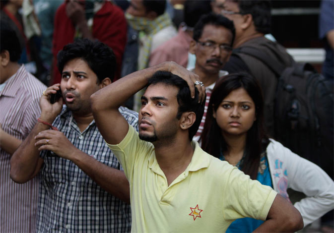 People stand outside a nursing home after it caught fire in Kolkata, India, Friday, Dec. 9, 2011. ? AP Photo