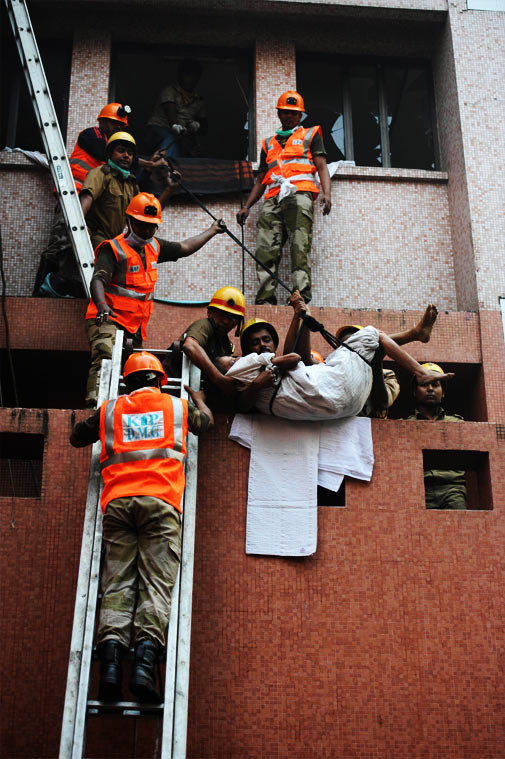 Rescue workers evacuate people after a fire engulfed a hospital in the eastern Indian city of Kolkata on December 9, 2011. ? AFP Photo