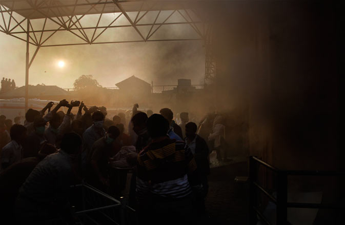 People rescue patients after a fire broke out at a nursing home in Kolkata, India, Friday, Dec. 9, 2011- AP Photo