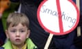 A boy holds a no smacking sign