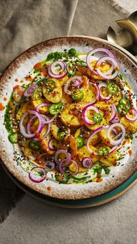 This amazingly colourful side of fried potatoes with all the the toppings will be welcome at any feast. The coriander chutney, chillies, and onions all bring the fire while the yoghurt underneath keeps it cool. An Ottolenghi classic.