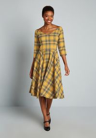 So superbly 50’s-inspired, this gorgeous yellow and navy tartan print swing dress is coming to you from Hell Bunny London!