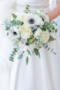 White and blue bouquet with anemones, delphinium, eucalyptus and roses.