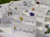 Each card has its own meadow flower, real pressed flower carefully glued on. The cards are already folded and ready to be placed on the table. Perfect for nature inspired wedding, dried flowers wedding, Rustic weddings. White, matte, decorative paper, 250 gsm, is used. You can choose a folded card or a flat card. -The size of a folded card is 9X4.5cm, 3.5X1.7 inches (Full size unfolded 9X9 cm, 3.5X3.5 inches). I can make cards with name and surname. -Flat card size: 9X4.5cm, 3.5X1.7 inches - Tag with golden hole and whatever text you want  size: 10X5 cm, 3.9X1.9 inches.  If you have any special requirements please write to me. Orders over 70 pieces have FREE & EXPRESS SHIPPING. Look here:   https://www.etsy.com/listing/1487518143/pressed-flower-place-cards-with-real?click_key=eca58308b3f2a