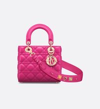 The Lady Dior My ABCDior bag epitomizes Dior's vision of elegance and beauty. Sleek and refined, the timeless style is crafted in fuchsia lambskin with Cannage stitching, creating the unmistakable quilted texture. Pale gold-finish metal D.I.O.R. charms embellish the silhouette with an elegant touch. Featuring a strap that can be personalized with badges, the small, unique design may be carried by hand or worn crossbody..