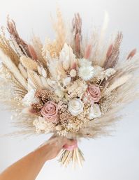 Everlasting wedding bouquet made from preserved and dried flowers including preserved roses, pampas grass, bunny tails, spear palm and others. Perfect as a wedding bouquet, to display in your home or as a beautiful gift for your loved ones. This is one sided bouquet. 🌸 SIZE * Bridal bouquet XL: approx 15 inch width / 38 cm * Bridal bouquet: approx 13 inch width / 33 cm - as shown in pictures * Bridesmaid bouquet M: approx 10 inch width / 25 cm * Bridesmaid bouquet S: approx 7 inch width / 18 cm