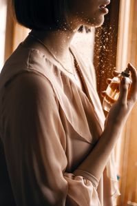 woman spraying perfume