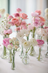 Pink flower compositions in small vases. Solifleur vases decorated with white dhalia, pink peonies, pink lisianthus, pink garden roses. Round table for two decorated for marriage proposal. Marriage proposal table decoration. Hotel de Paris in Monaco.