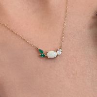 This beautiful, 14K gold-cast necklace is inspired by the tranquility of a lush evergreen. Adorned with a cluster of gorgeous gemstones, including an Australian opal and two emeralds, it's finished with a sparkly pear-cut lab diamond.