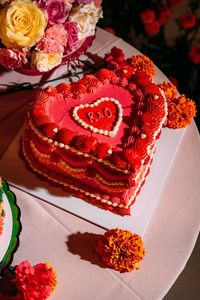 Heart shaped retro wedding cake with pink and orange icing | David Scholes Photography | <a href="https://www.rockmywedding.co.uk/sefton-park-palm-house" target="_blank" rel="noopener">See more of this wedding</a>