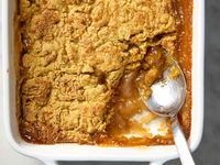 overhead shot of caramel apple dump cake in a white baking dish, with a scoop taken out of the bottom right corner