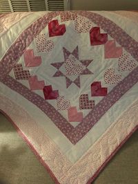 Hand pieced baby valentine quilt is free motion quilted. I love the colors. The back has the same tiny hearts fabric as the border. I loved making it.