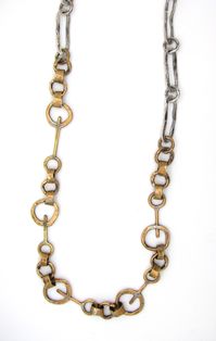 Silver & Brass Necklace - Passentis Brass Key Links with Hammered Ovals is a unique statement chain. She crafts each component on her anvil in the art studio. This chain measures 34 long and does not have a clasp. .5W.Clean using warm water and soap or lightly rub with a polishing cloth.