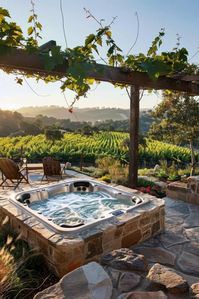 stone hot tub overlooking vineyard