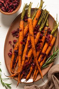 This recipe for Maple Herb Glazed Roasted Carrots with cranberries is a beautiful vegetarian side dish for Thanksgiving and the holidays.