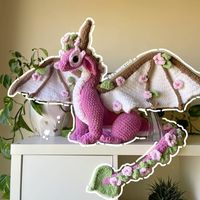 Crochet Cherry Blossom Dragon  This pattern is a beautiful and unique way to add a touch of nature to your home. The dragon is made with a soft, fluffy yarn and features delicate cherry blossoms. It's perfect for a child's bedroom or a nature-lover's,#Amigurumi_Patterns #Crochet_Animals_Dragon #Cute_Crochet_Dragon #Toothless_Amigurumi_Free_Pattern