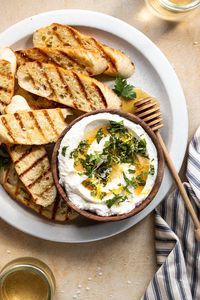 In just 10 minutes, creamy ricotta cheese is whipped to perfection and served with honey, lemon and fresh herbs for an ultra flavorful combination. Store-bought whole milk ricotta, or homemade whole milk ricotta work wonderfully! Serve as dip, spread, or easy crostini appetizer.