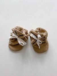 These ultra-soft, organic cotton fleece booties are easy to tie for a snug, custom fit, keeping those wiggly baby toes comfortably covered at all times. Pro Tip: Double knot the bow as you prefer and simply slide them on and off. They are perfect with teeny bare feet or with our Ribbed Onesie or Ribbed Legging. This pi