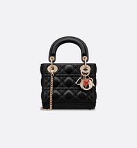 Part of the Dioramour capsule, the Lady Dior bag embodies the House's vision of elegance and beauty. Sleek and refined, the timeless design is crafted in black lambskin with Cannage stitching, creating the instantly recognizable quilted texture. The silhouette is elevated by pale gold-finish metal D.I.O.R. charms and a red enamel heart charm. The miniature style has a thin, removable chain strap, allowing it to be carried by hand or worn crossbody. It will coordinate well with other Dioramour cr