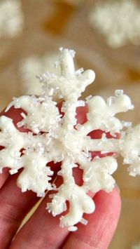 How To Make White Chocolate Snowflakes ~ melted white chocolate piped into the shape of a snowflake and sprinkled with shimmer white sugar. These make adorable cupcake and cake toppers!