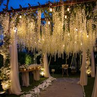 Elevate your wedding with an enchanting overhang, adorned with bistro lights and artificial wisteria! ✨🌿 Create a magical ambiance that adds romance and charm to your ceremony or reception. Perfect for outdoor or garden weddings, this stunning overhang casts a warm, romantic glow, while the delicate wisteria adds a touch of natural beauty. Dance the night away under this dreamy canopy and create unforgettable memories that will last a lifetime! #WeddingDecor #OutdoorWedding #RomanticAmbiance 🌸💫🕯️#Ad#Promotion