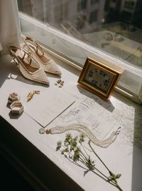 Wedding day flat lay detail of bride's shoes and jewelry.