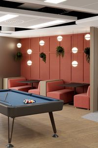 An office break out / cafe area with pool table, terracotta blush wall panels and booths adorned by hanging lights and plants to create a warm and playful space