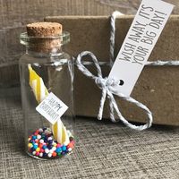 Mini message in a bottle birthday party invitation or gift. Candle and sprinkles in the bottle. Candle has a hand-foiled birthday with message. Adorable idea for a kids birthday.