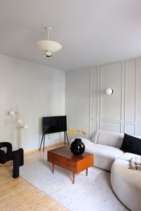 Minimalistischer Wohnstil für dein Wohnzimmer mit danish modern Details. Kombiniere eine helle Wandfarbe mit dunklen Accessoires.