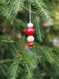 Modern Christmas ornaments - These Nordic ornaments were created by combining my two favourite materials, ceramics and wood. The ceramic beads have been handmade and hand-painted with a rich red and a glossy white glaze. These Scandinavian Christmas ornaments were inspired by the Nordic design and are very typical of Nordic Christmas decor. These modern and minimalist Christmas decorations will add a touch of nordic style to your holidays. They can be purchased individually or as a set of three.