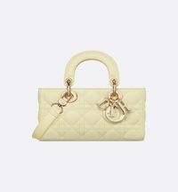 The Lady D-joy Bag Captures The House's Vision Of Elegance And Beauty By Showcasing The Streamlined Aesthetic Of The Iconic Lady Dior Line. Crafted In Pastel Yellow Lambskin With Cannage Stitching, The Refined And Timeless Style's Quilted Texture Is Unmistakable. The D.i.o.r. Charms Embellished In Transparent Tonal Resin Illuminate Its Silhouette. Featuring One Removable Chain Strap And Another Adjustable And Removable Leather Strap, The Small Lady D-joy Bag Can Be Carried By Hand, Worn Over The