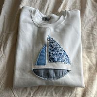 Gildan Heavy Blend crewneck with a patchwork sailboat hand-sewn by me using fabric scraps. - Crewneck color: white - Unisex - Size up for an oversized fit! - Content: 50% Cotton, 50% Polyester - Care: machine wash, cool, non-chlorine bleach when needed, tumble dry, medium, do not iron, do not dry clean