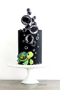 Watch the video tutorial that shows you how to make this full cake project, from the hand crafted, edible sea turtle and the painted bubbles, to building and covering a double barrel cake with fondant and tips on which black fondant to use... all on Cakeheads.com!