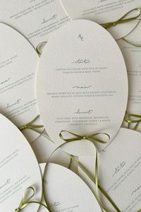 Custom oval menus with olive green bows, printed on luxury cream card. By Lyrah Studio.