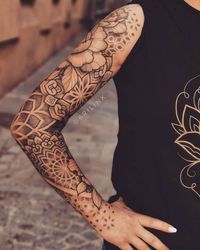 Floral-Mandala Arm with intricate floral and geometric sleeve tattoo in black ink, woman wearing black tank top with subtle design. | Sky Rye Design