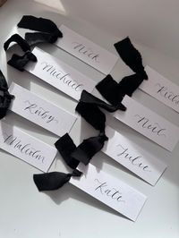 *please email names to thoughtfullymadeuk@outlook.com or add them to the order notes at checkout* Handwritten Calligraphy Style Place Cards perfect for weddings and events!✑ Handwritten Calligraphy ✑ Smooth White Card✑ Silver or Gold eyelet ✑ Luxury 'silk style' Chiffon Ribbon✑ All place card orders are tracked (not including samples)✑ Check estimated dispatch time, this varies in low/high season✑ Message for rush ordersRibbon Colours;Please order via correct listing - view available colours here: https://thoughtfullymadeuk.com/collections/calligraphy-place-cards♥ Eucalyptus ♥______(similar to Sage, Green, Forest Green, Dark Green)♥ Blush ♥___________(similar to Pink, Baby Pink)♥ Navy ♥___________(similar to Royal Blue, Airforce Blue, Dark Blue)♥ Black ♥___________♥ Champagne ♥______(simil