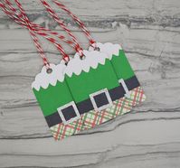 "These Elf suit gift tags are perfect addition to your Christmas gift wrap this holiday season.  They look great on a teacher, coworker, or child's gift.  You can even tell your neighbor they've been elfed with this cute tag. SIZE: *1.75\"x 2.75\" COLOR: *Green, red, white, and black *Silver glitter FEATURES: *Made from heavy duty, laser cut card stock *Green textured card stock and a silver glitter belt buckle *Comes with attached red and white bakers twine *Back of tag has a to/from label for you to write in those special names or you can choose for it to be blank *Sold in sets of 6 for $6 or 12 for $10 Each tag is handmade, so please allow for slight differences."