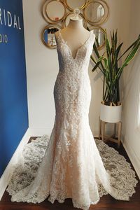 Lace fit and flare bridal gown with v-neckline, v-back, and long illusion lace train, available off the rack at Silk Bridal Studio