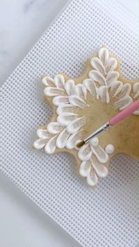 Inspired by @sweetambs designs, we decorated our snowflake cookie using a simple brush embroidery method. Use a food-safe paintbrush and thick flood consistency royal icing to acheive this elegant effect. Cookie decurated by @butterflybakesatl