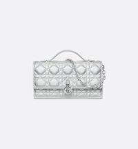 The My Dior mini bag expands the line with an elegant and functional design. Crafted in iridescent metallic silver-tone Cannage lambskin, it features a flap enhanced by D.I.O.R. charms on the front. Equipped with compartments and card slots, the functional accessory holds all the essentials and is the ideal day and evening companion. A top handle completed by a removable chain punctuated with resin pearls allows the bag to be carried by hand or worn crossbody..