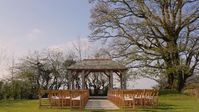 Outdoor ceremony wedding under arbour, gazebo. Photo by Charlotte Dart